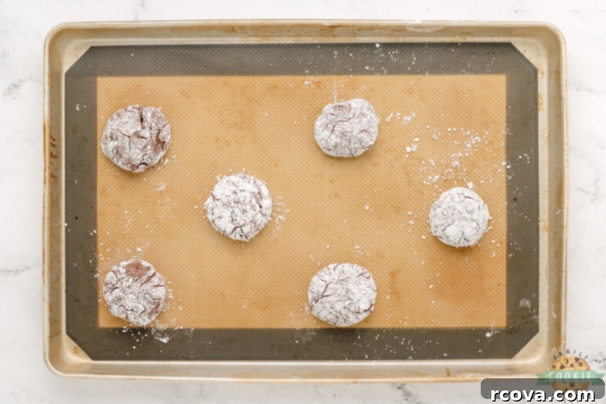Fudgy Brownie Crinkles 6 Roll cookie dough balls in powdered sugar.