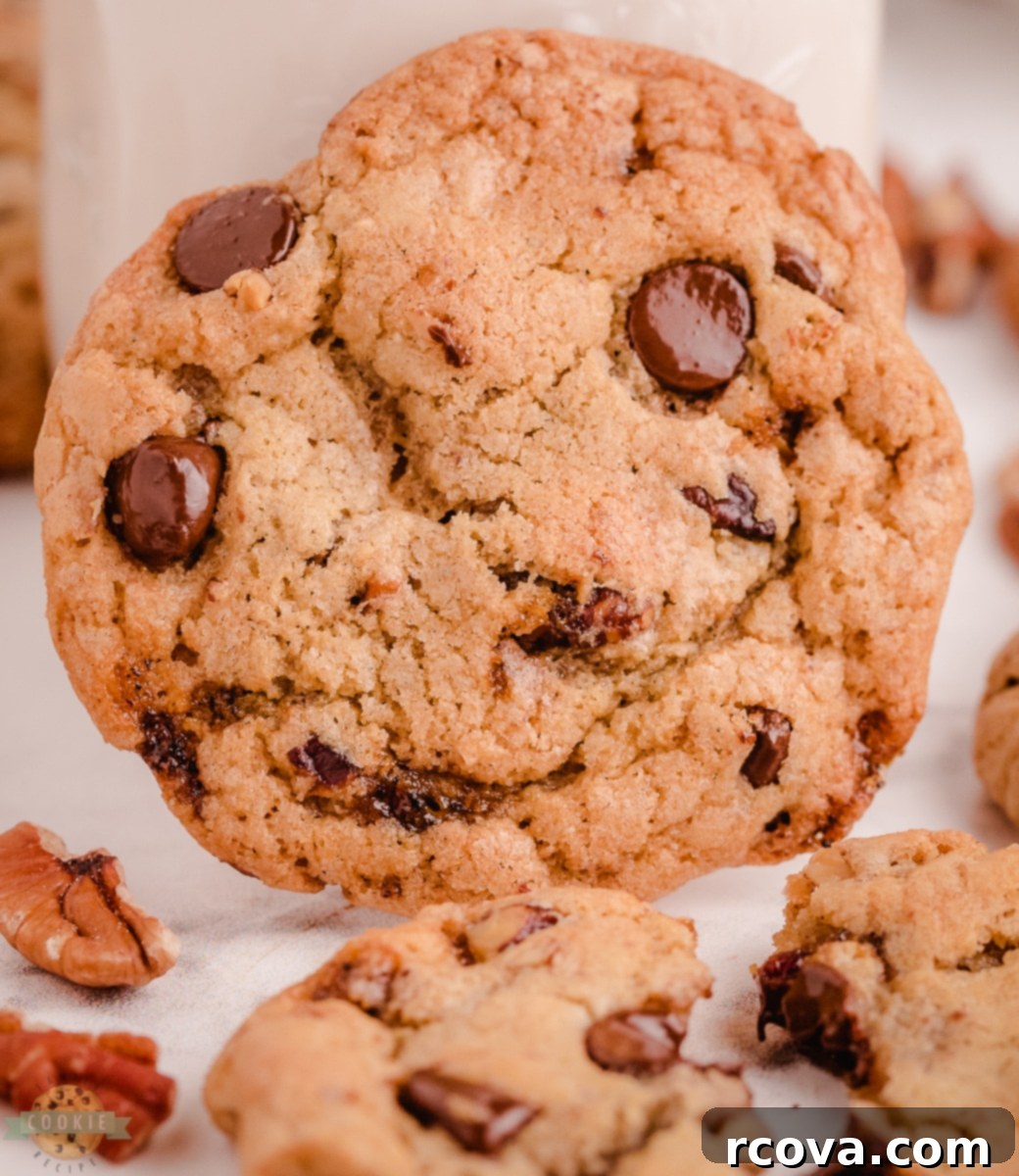 Irresistible Butter Pecan Chocolate Chip Cookies 3 Close-up of baked Butter Pecan Chocolate Chip Cookies on a parchment-lined baking sheet, golden and inviting.