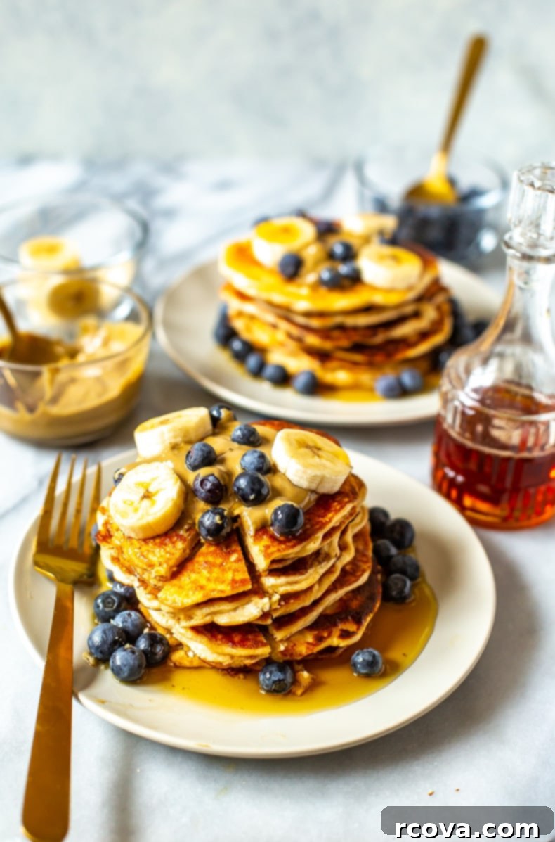 Power-Packed 4-Ingredient Fluffy Pancakes 7 A stack of golden brown 4-Ingredient Protein Pancakes with berries and syrup.