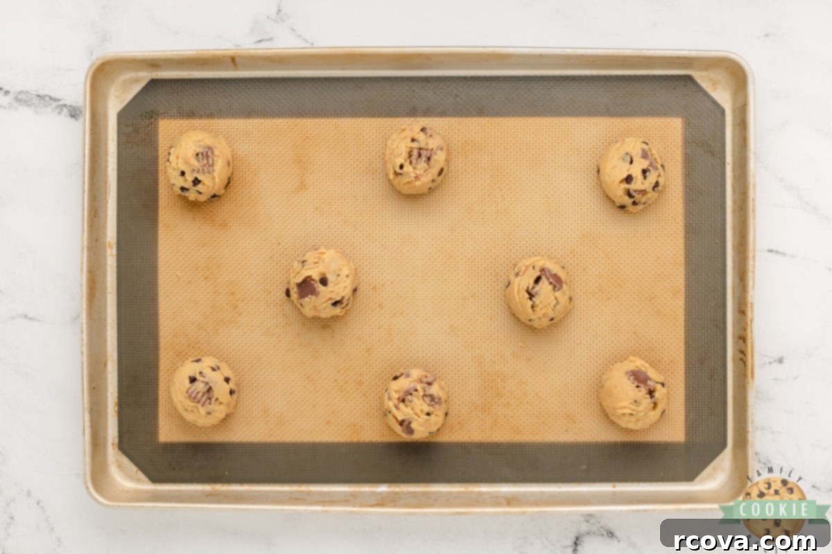 Reese's Peanut Butter Pudding Cookies 13 Using a cookie scoop to portion uniform balls of Reese's Peanut Butter Pudding Cookie dough onto a baking sheet.