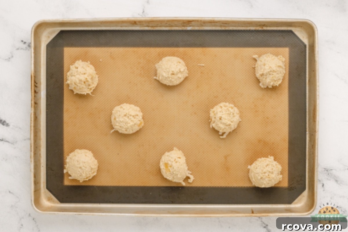 Piña Colada Paradise Bites 12 Scooping pina colada cookies onto cookie sheet.