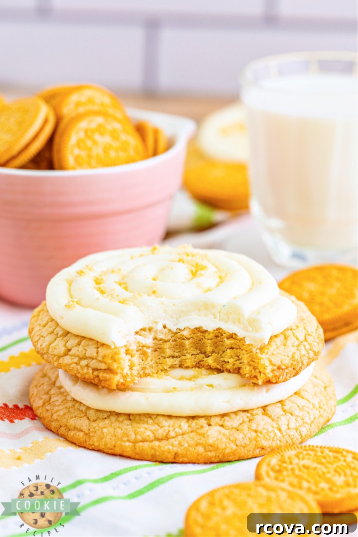 Crumbl-Inspired Golden Oreo Cookies 2 Large, frosted Copycat Crumbl Golden Oreo Cookies on a white plate, showcasing the thick vanilla base and creamy frosting.