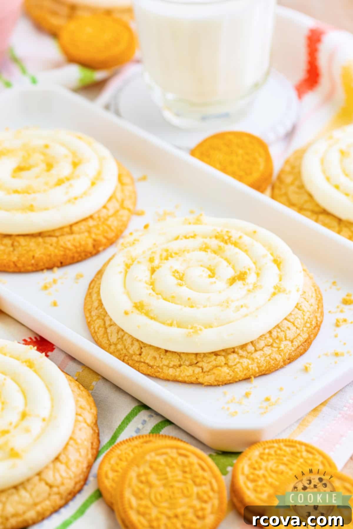 Crumbl-Inspired Golden Oreo Cookies 5 Baked vanilla cookies with generous swirls of cream cheese frosting and a sprinkle of Golden Oreo crumbs on a wire rack.