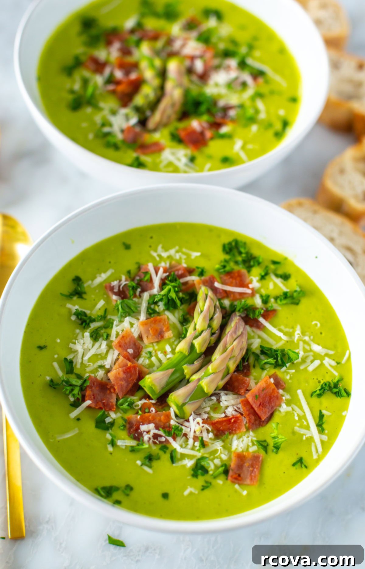 Simple Creamy Asparagus Soup 8 Two artfully arranged bowls of Cream of Asparagus soup on a table, highlighting its fresh appeal.