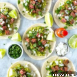 Sizzling Carne Asada Tacos 11 Assembled carne asada tacos garnished with cilantro and lime wedges
