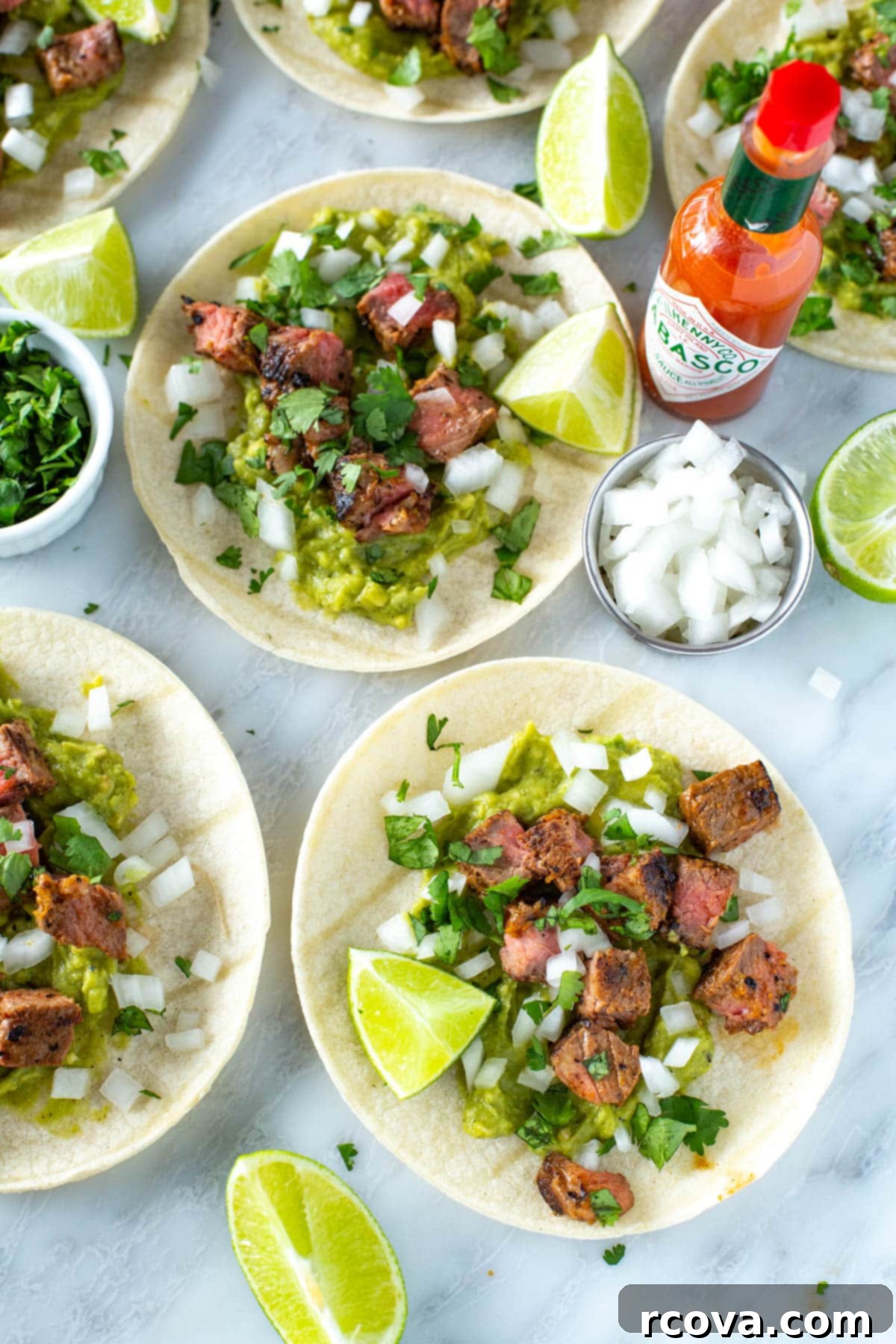 Sizzling Carne Asada Tacos 9 Carne asada tacos garnished with fresh lime wedges and cilantro, ready to be enjoyed.