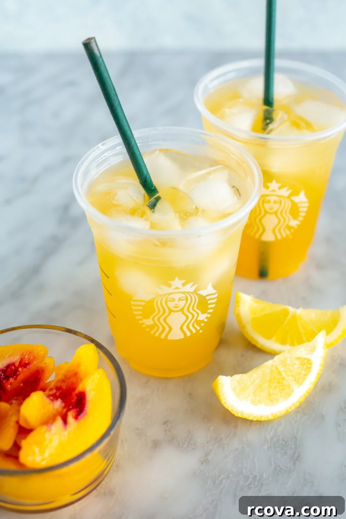 Starbucks Refreshing Iced Peach Green Tea Lemonade 7 Two copycat iced peach green tea lemonades in clear glasses with straws.