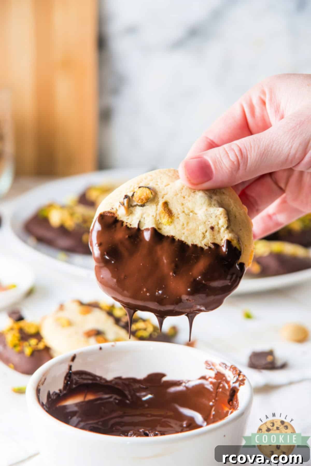 Chocolate Kissed Pistachio Delights 4 Dipping a pistachio cookie in melted dark chocolate.