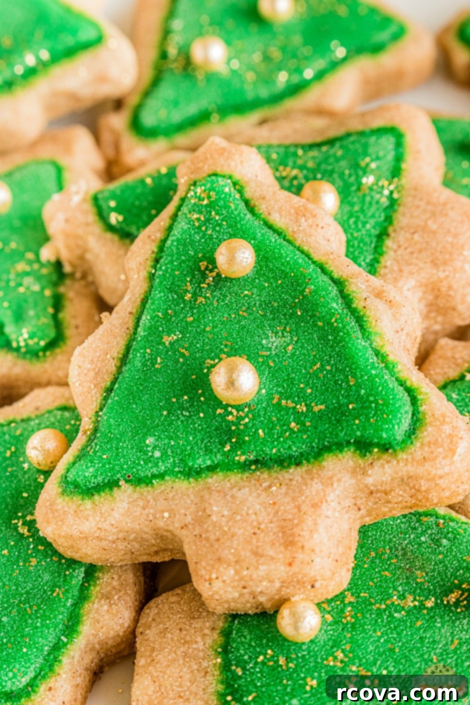 Holiday Spiced Shortbread Delights 5 Spiced Christmas Shortbread Cookies, decorated with white icing and green leaf sprinkles, on a festive background.