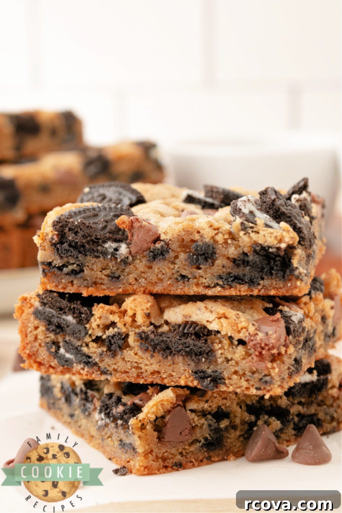 Ultimate Oreo Bars 5 A close-up view of thick, chewy cookie bars, highlighting the generous amount of Oreo pieces mixed throughout the dough.