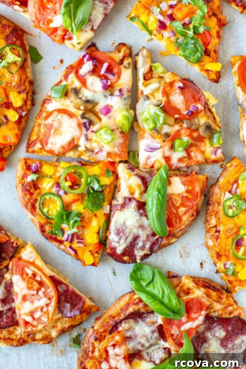 Quick and Easy Pita Pizza 3 Ways 9 Three pita pizzas on a cutting board, one deluxe, one margherita, and one tex-mex, ready to be served.