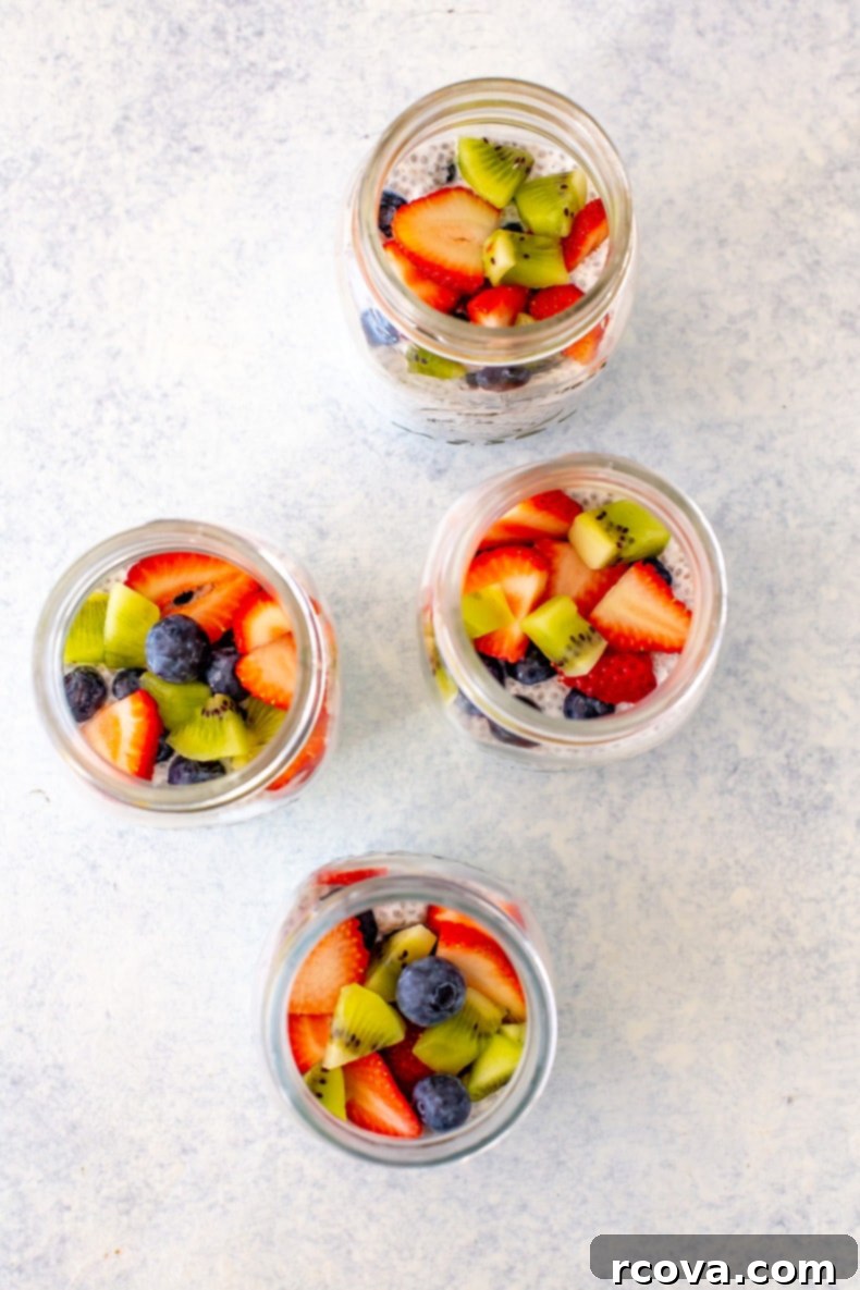 Easy 4-Ingredient Protein Chia Pudding 9 Four mason jars of high-protein chia pudding, some topped with various fruits, showcasing different meal prep options.