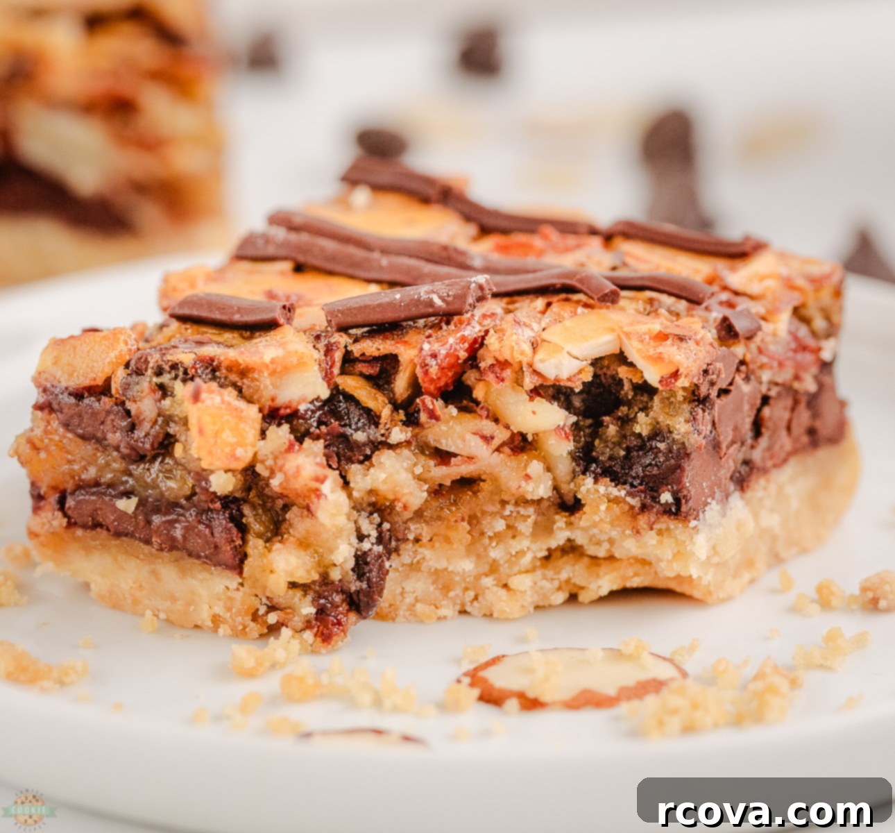Decadent Chocolate Almond Bars 2 A chocolate almond bar with a bite taken out, showing the layers of shortbread, fudge, and almonds
