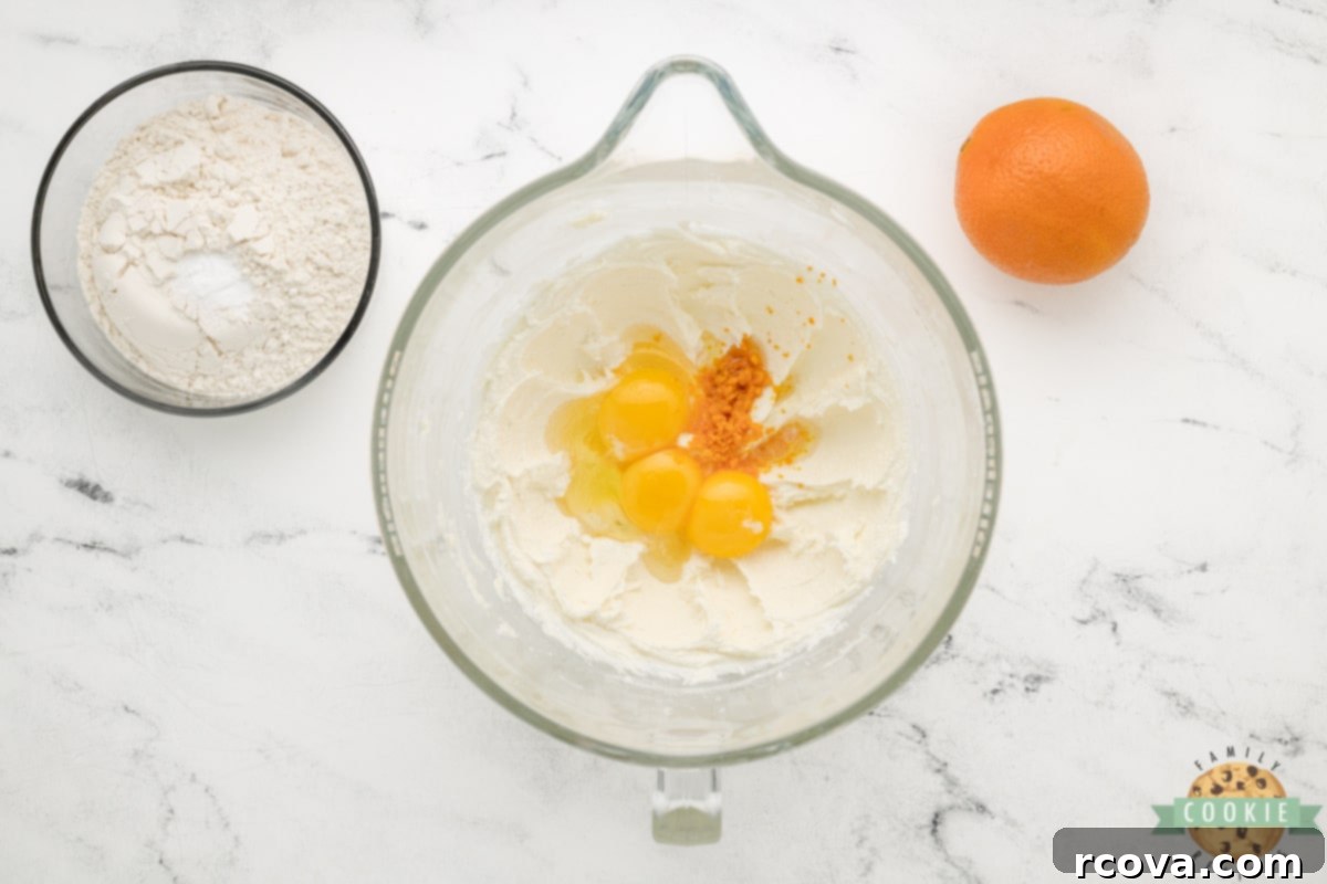 Decadent Orange Fudge Cookies 7 Adding egg, egg yolks, fresh orange peel, and orange extract to the creamed butter and sugar mixture.