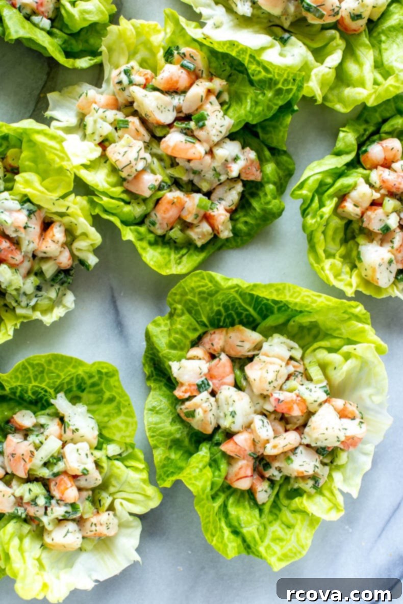 Irresistible Shrimp Salad 8 A beautifully presented bowl of creamy No-Cook Shrimp Salad with a side of avocado and fresh lemon wedges, ready for serving.