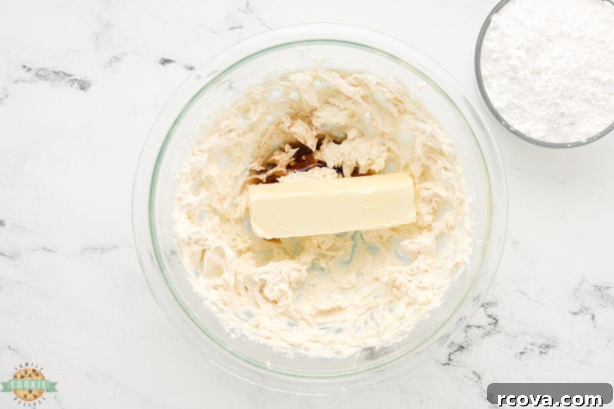 Irresistible White Chocolate Cranberry Cookie Bars 11 Adding softened butter and vanilla extract to the beaten cream cheese mixture for the frosting.