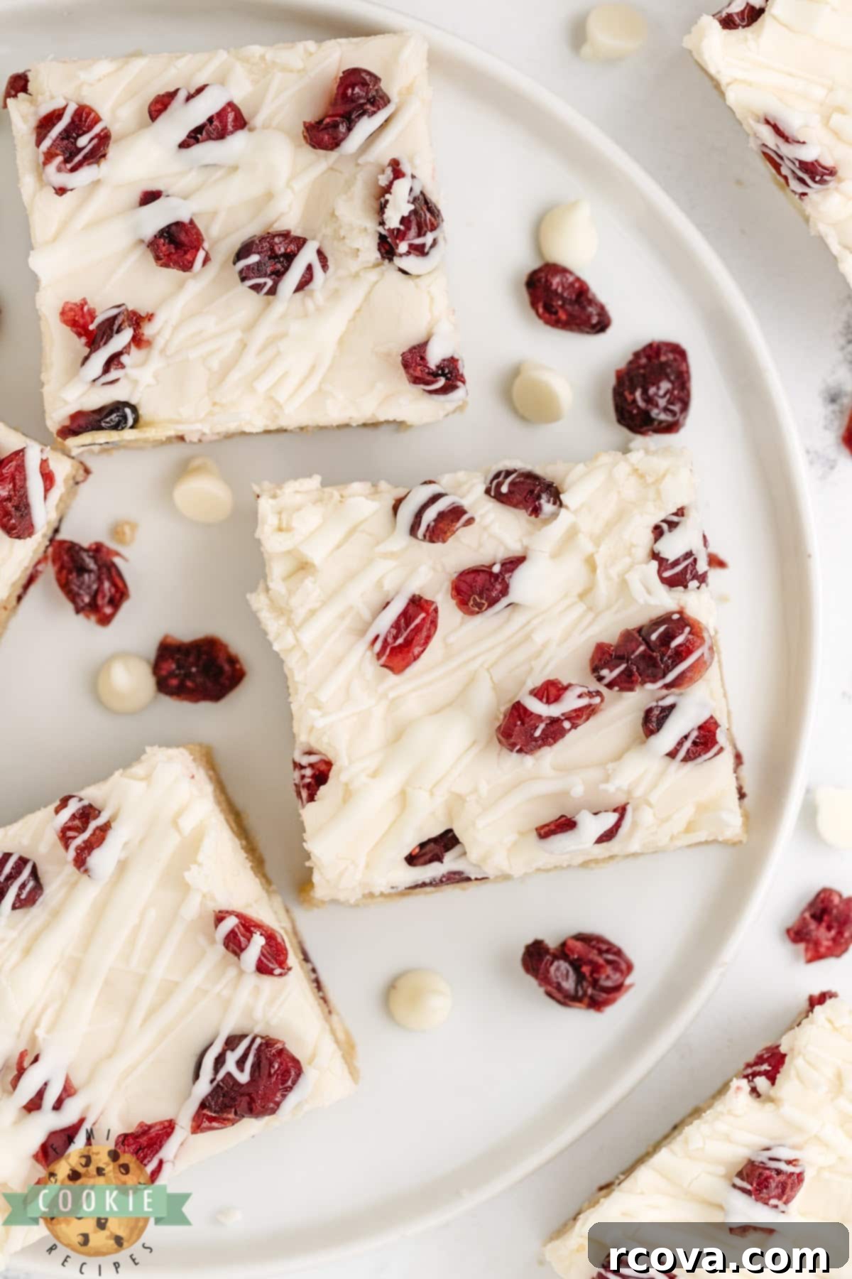 Irresistible White Chocolate Cranberry Cookie Bars 19 Fully assembled White Chocolate Cranberry Cookie Bars, topped with cream cheese frosting, dried cranberries, and a white chocolate drizzle, ready to be served.