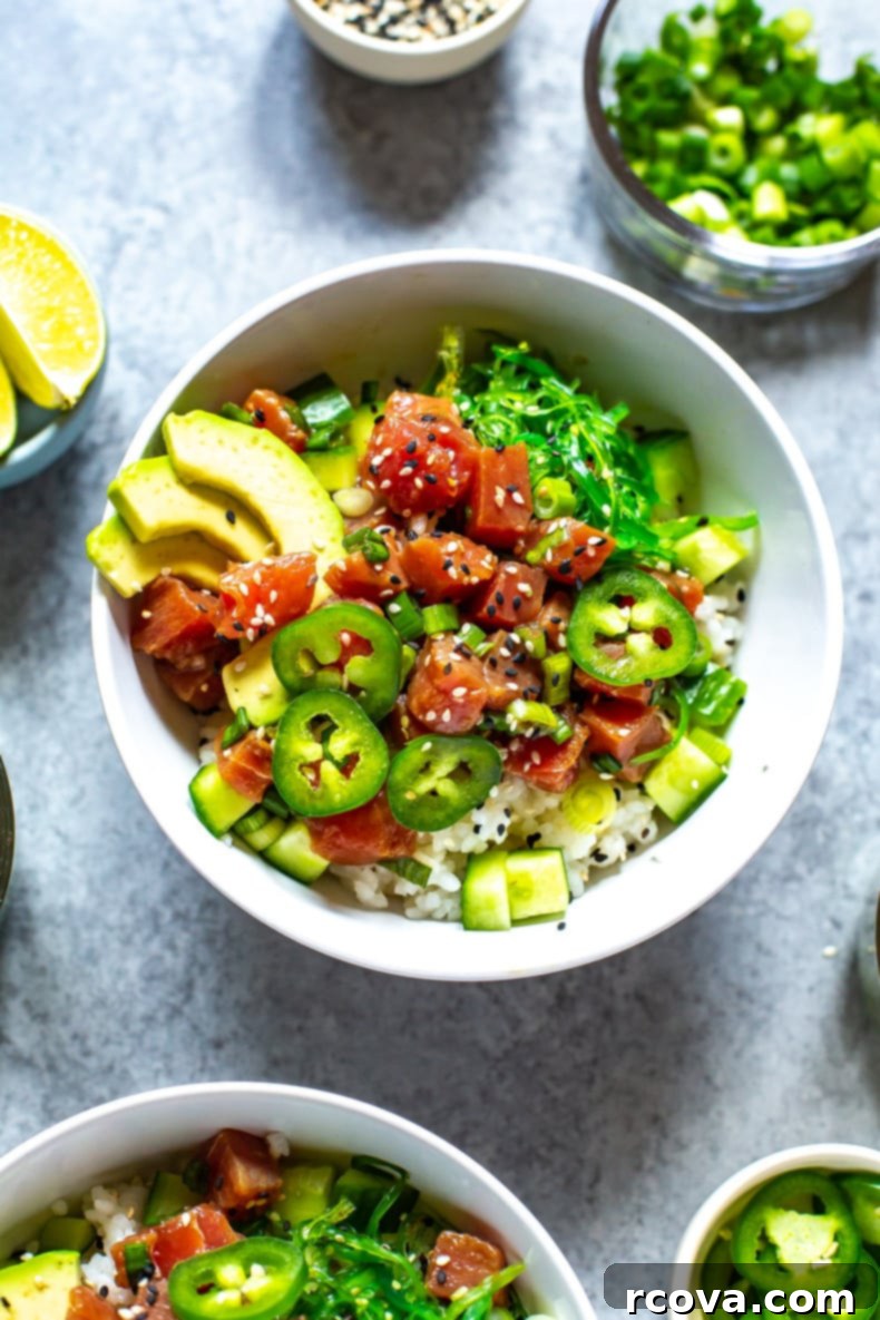 Over 25 Delicious No-Cook Recipes for Summer 18 A close-up of an ahi tuna poke bowl topped with avocado slices, jalapeno slices, and sesame seeds.