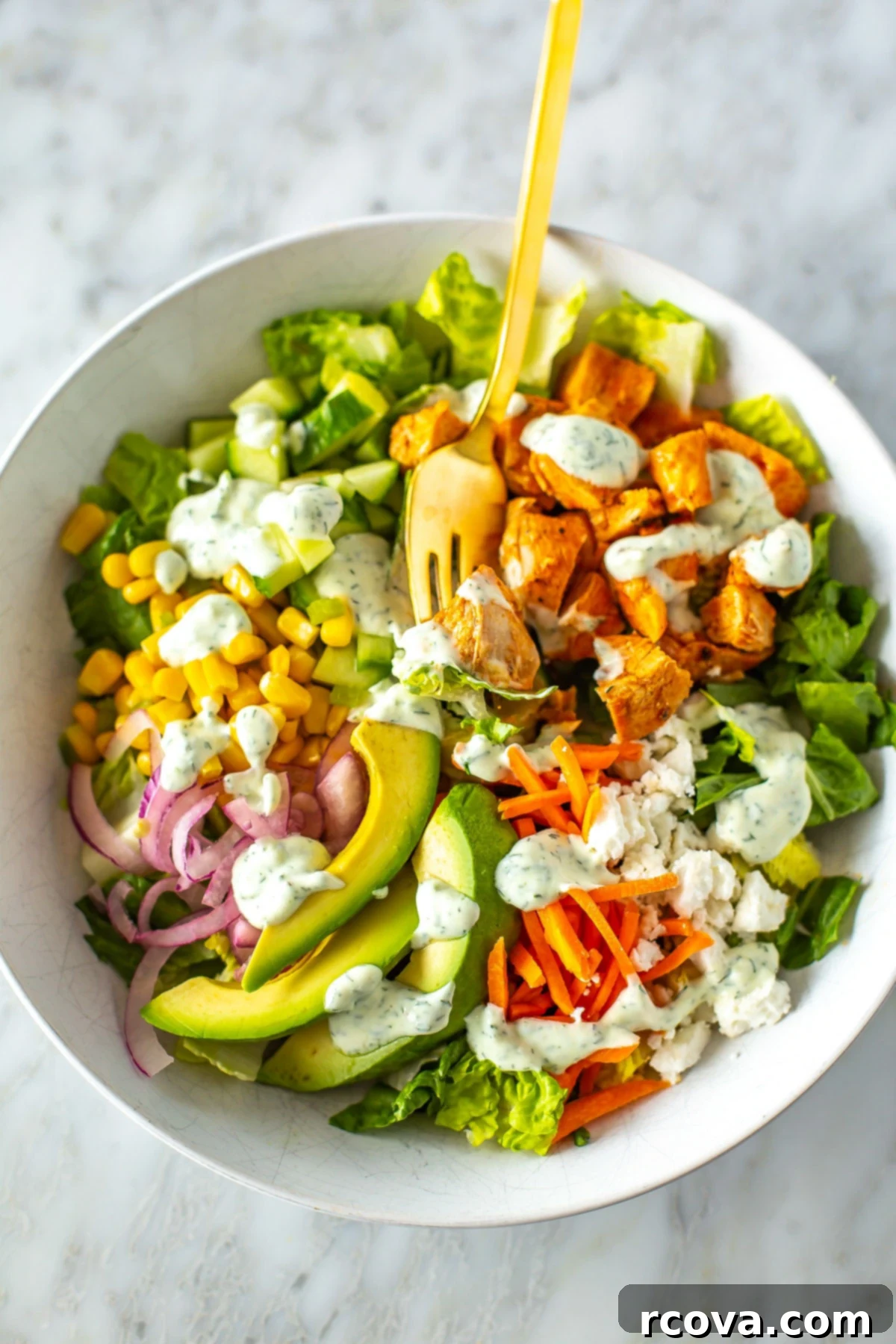 Over 25 Delicious No-Cook Recipes for Summer 25 A close-up of a bowl of buffalo chicken salad with ranch dressing drizzled over top.