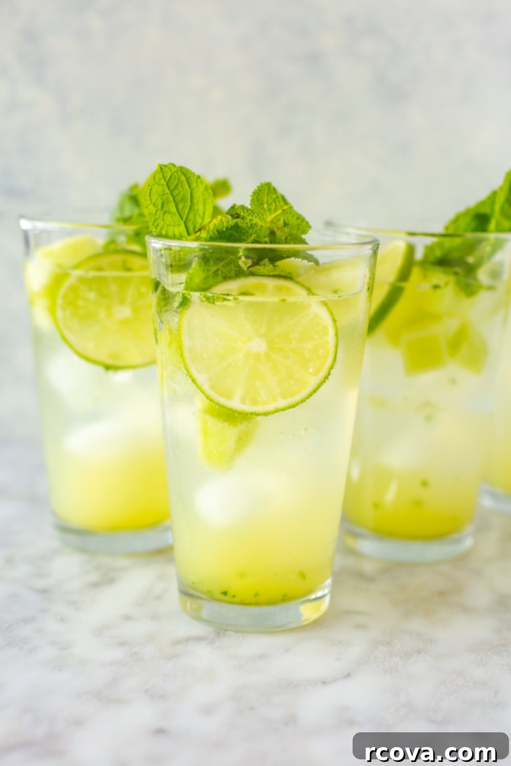 Summer's Coolest Sips 5 Three perfectly garnished honeydew mojitos in tall glasses, inviting a refreshing sip.