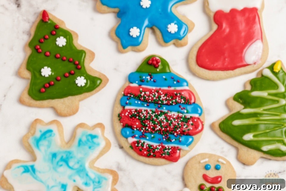 Crafting Christmas Cookie Magic 2 Classic Christmas Cut-Out Cookies perfect for the holidays! Easy sugar cookies for cookie cutters with a simple shiny cookie icing that everyone loves. Festive sugar cookies adorned with shiny royal icing and colorful sprinkles on a cooling rack.
