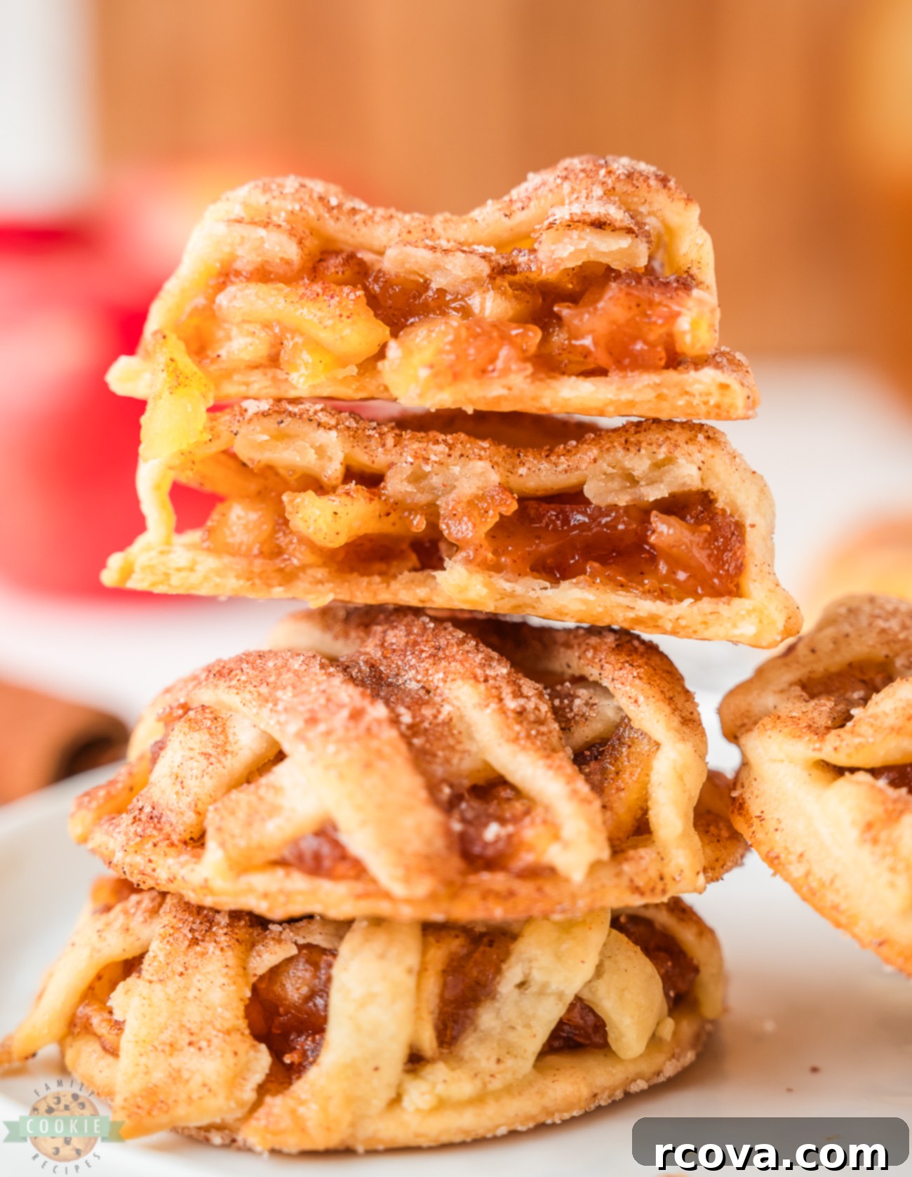 Spiced Apple Pie Delights 2 A stack of golden brown spiced apple pie cookies, topped with a delicate lattice crust and a sprinkle of cinnamon sugar, invitingly displayed.