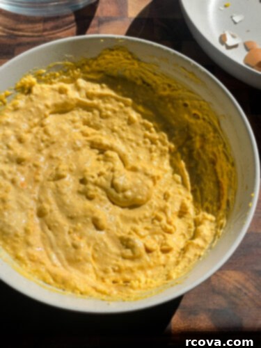 Fiery Sriracha Bacon Deviled Eggs 7 mashed egg yolk filling in a bowl before spooning into egg halves.