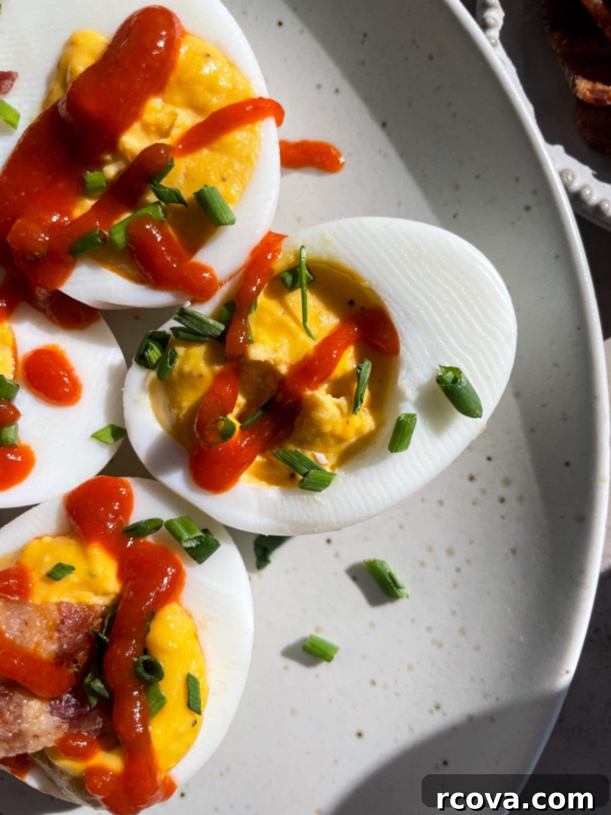 Fiery Sriracha Bacon Deviled Eggs 10 Deviled eggs without bacon, garnished with chives and paprika for a vegetarian option