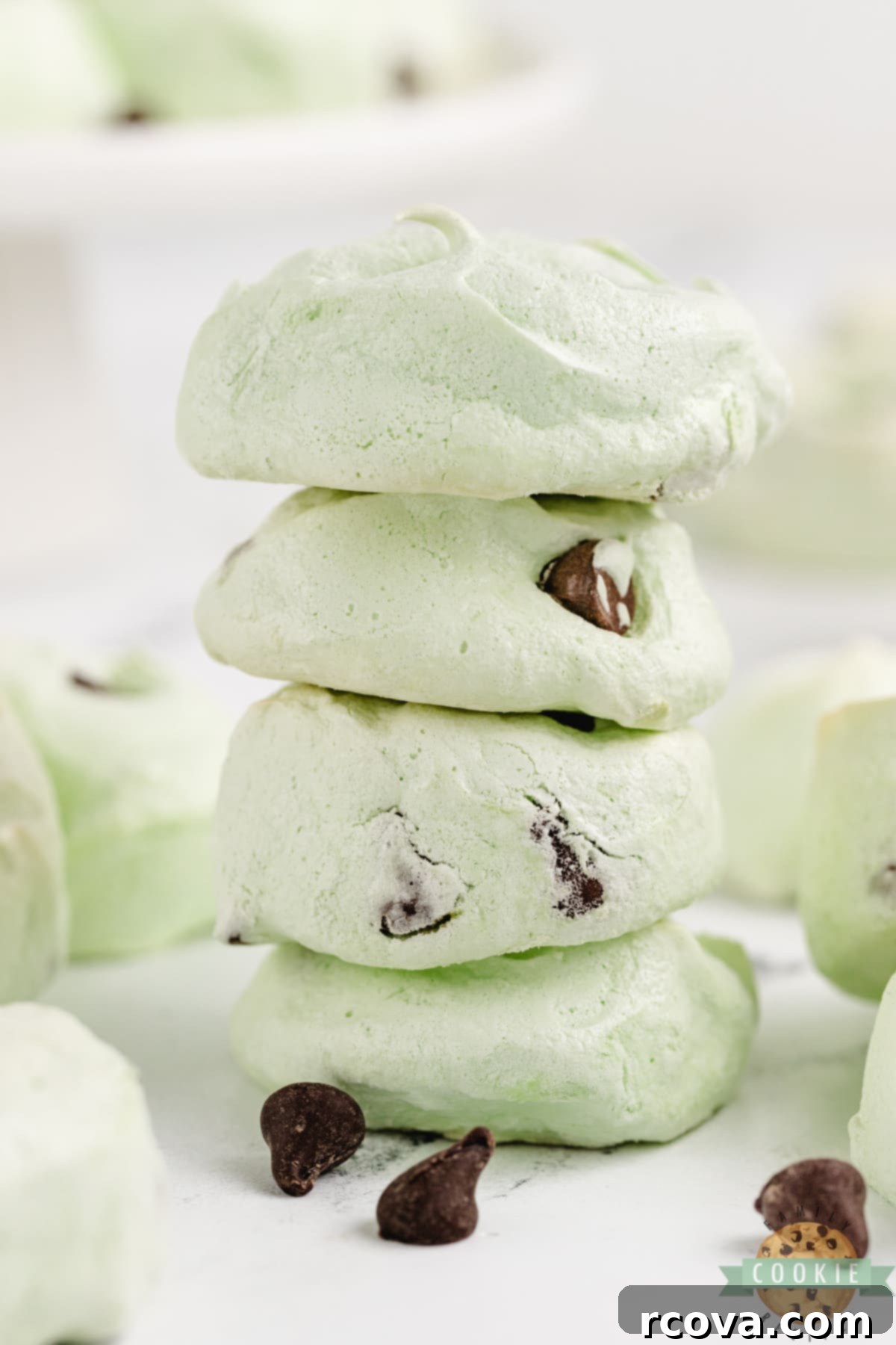 Cool Mint Chocolate Chip Meringue Clouds 11 A beautiful stack of light green Mint Chocolate Chip Meringue Cookies, showcasing their delicate structure and hints of chocolate.