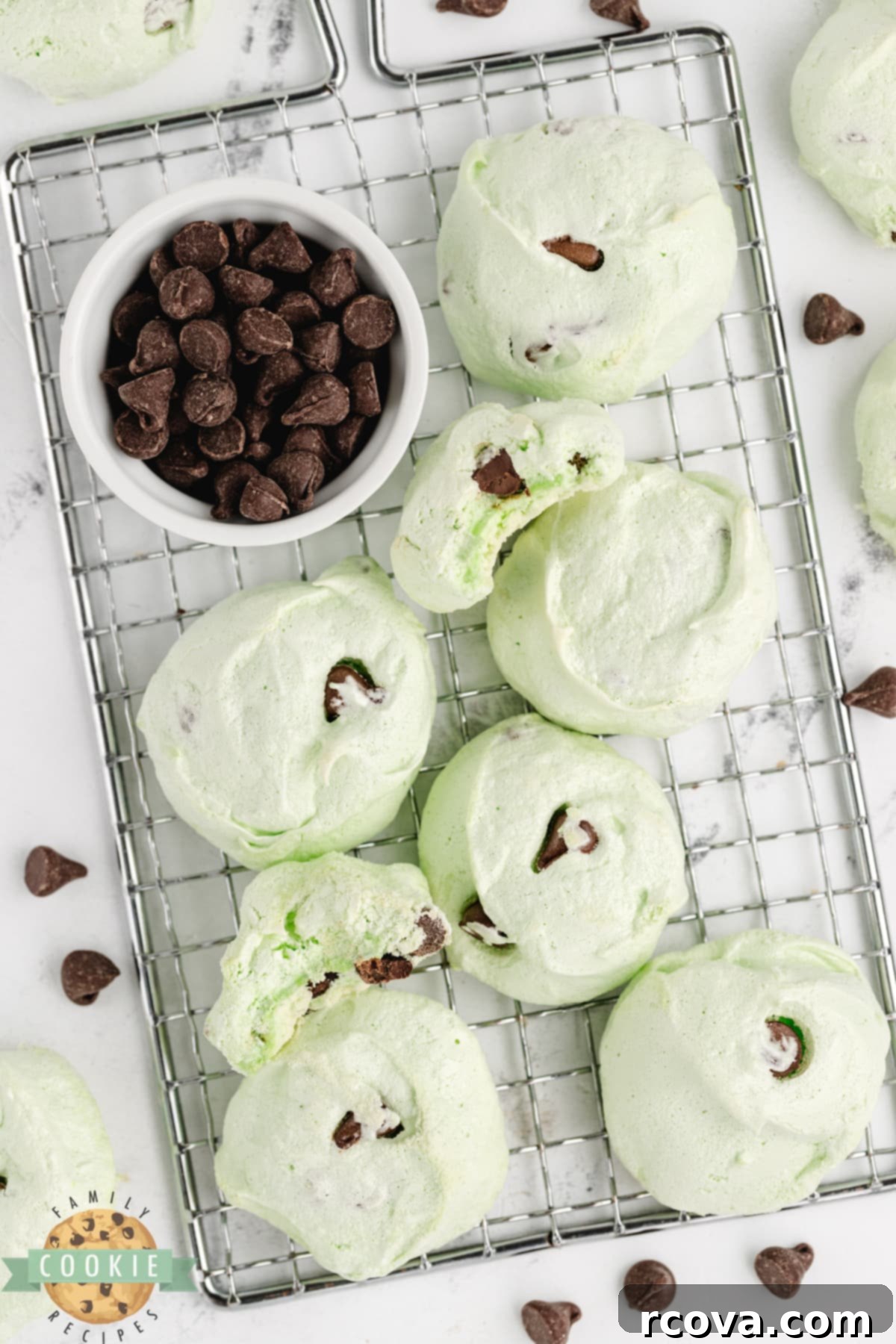Cool Mint Chocolate Chip Meringue Clouds 4 Mint Chocolate Chip Meringue Cookies cooling on a wire rack after baking, showcasing their crisp texture and vibrant color.