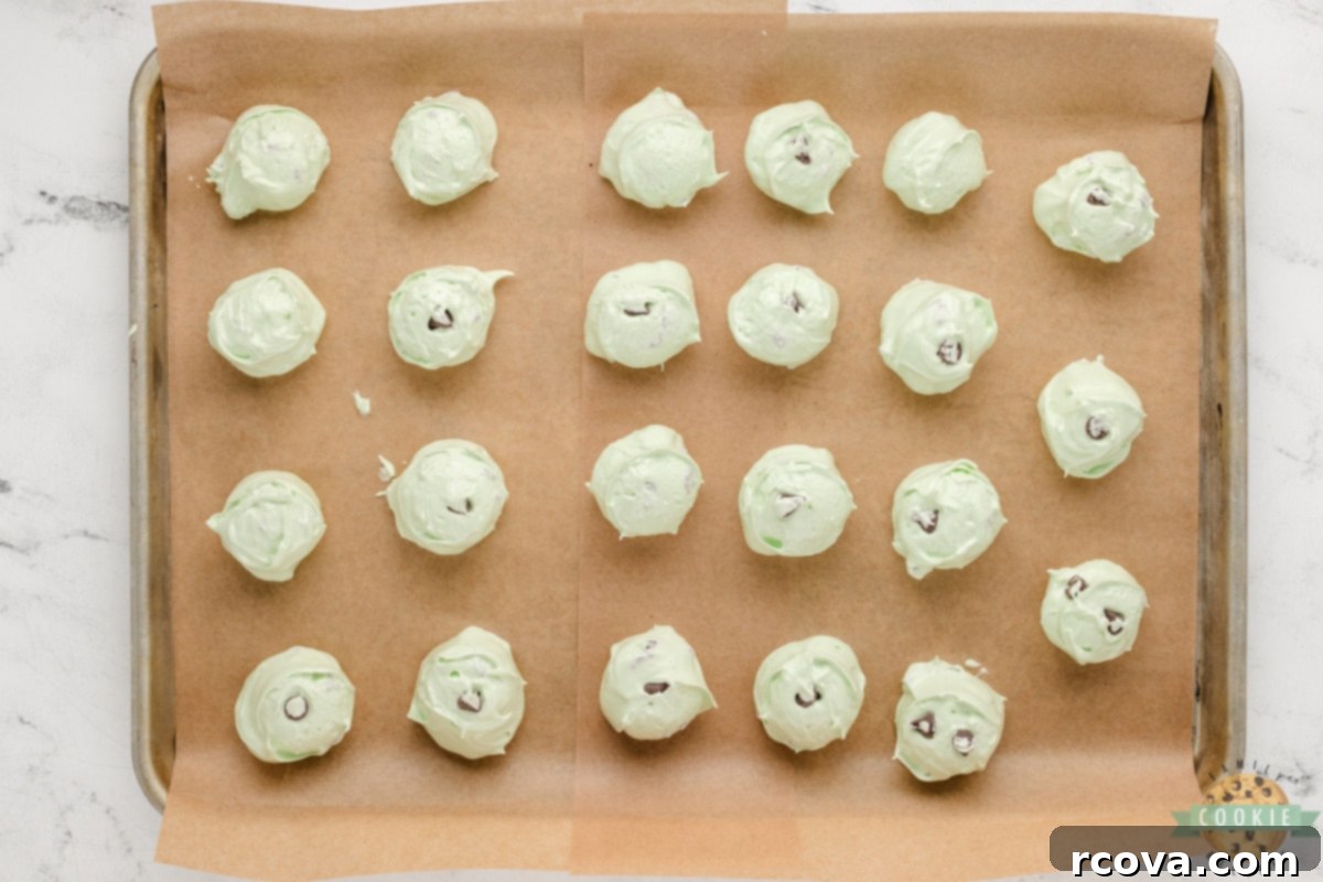 Cool Mint Chocolate Chip Meringue Clouds 8 Mini semi-sweet chocolate chips being gently folded into the green meringue mixture with a rubber spatula.