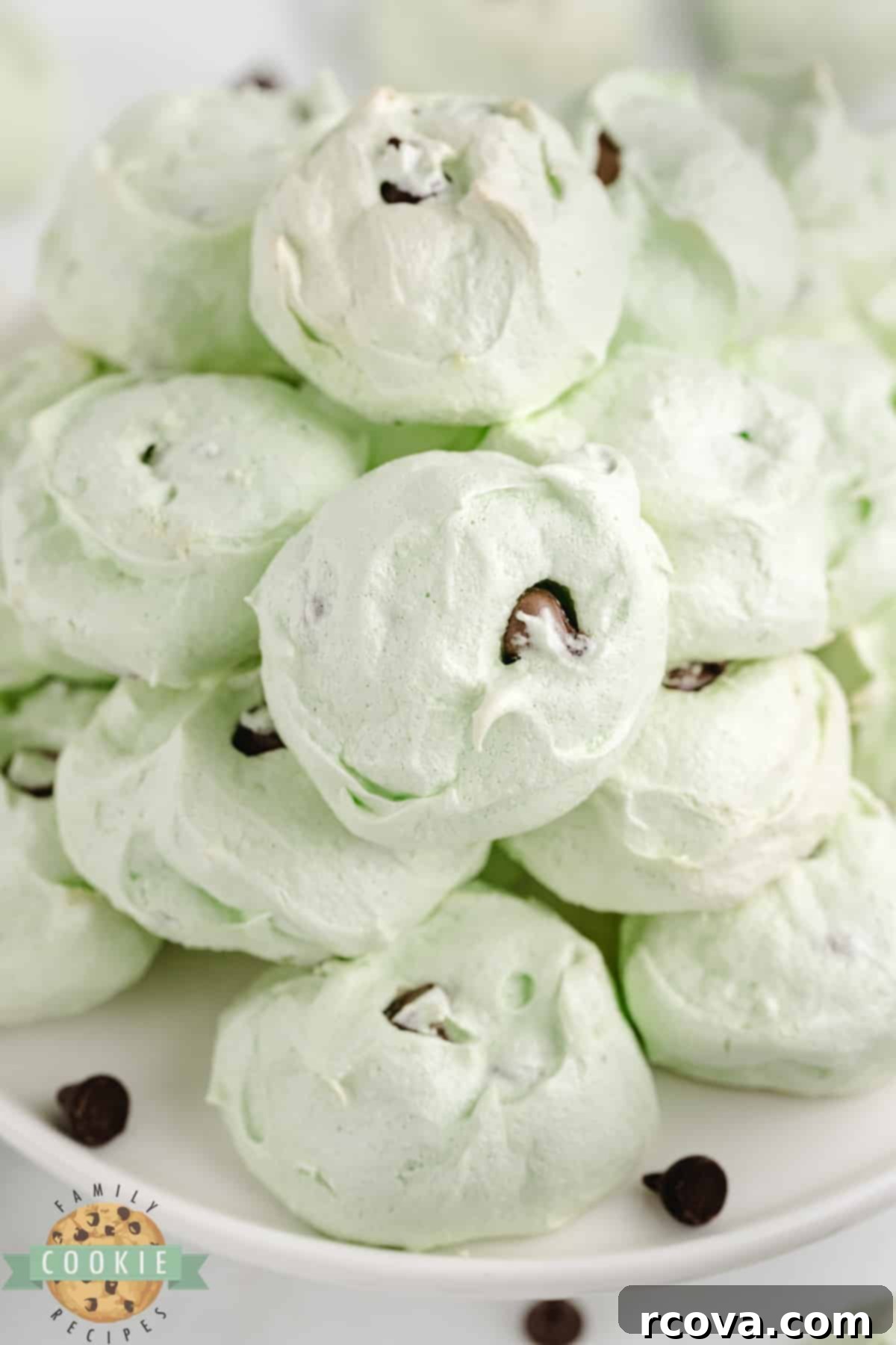 Cool Mint Chocolate Chip Meringue Clouds 9 A cluster of delicious Mint chocolate chip meringue cookies, showcasing their light green color and delicate, airy texture with visible chocolate chips.