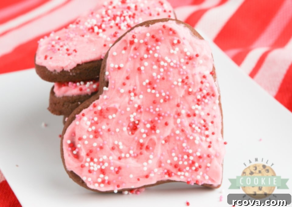 Irresistible Chocolate Sugar Cookies 6 A tray of beautifully decorated chocolate sugar cookies with pink frosting and sprinkles.
