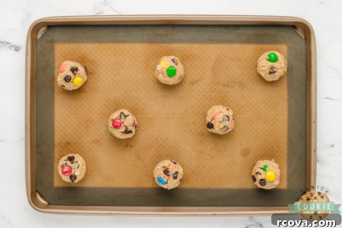 Easy 5-Ingredient Monster Cookies 8 Scooping even balls of Monster Cookie dough onto a parchment-lined baking sheet.