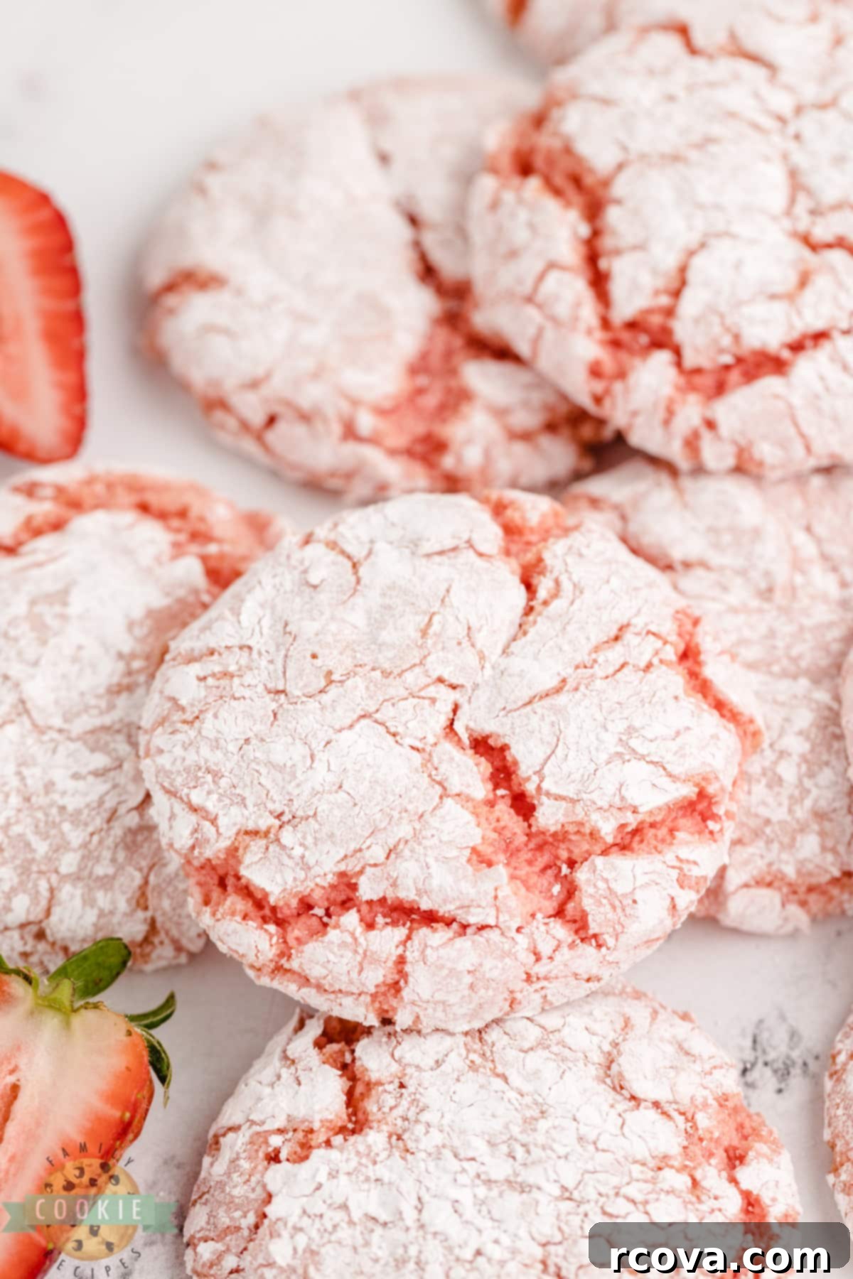 Whipped Strawberry Cloud Cookies 3 A stack of freshly baked strawberry cookies, lightly dusted with powdered sugar, on a cooling rack, highlighting their vibrant color and delicate appearance. Perfect for a quick and easy dessert.