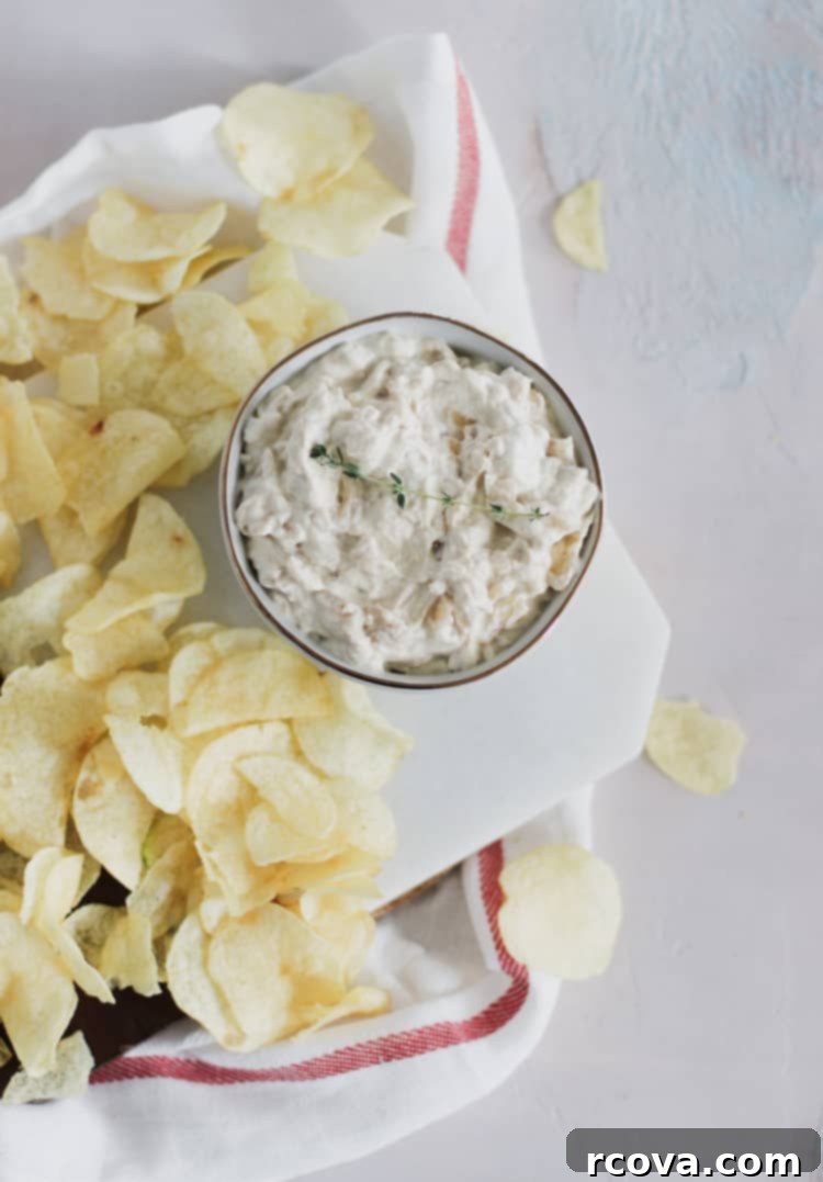 Creamy Greek Yogurt French Onion Dip 2 A vibrant bowl of homemade lightened up French onion dip made with Greek yogurt and caramelized onions, garnished with fresh chives, served with an assortment of dippers like potato chips, carrot sticks, and bell pepper slices. Perfect for any get together, with a lot less guilt!