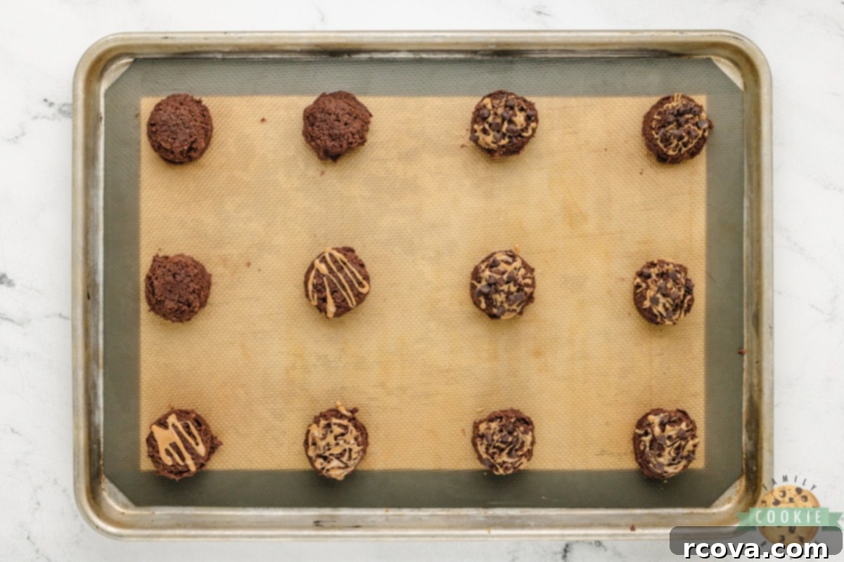 Irresistible Chocolate Peanut Butter Swirl Cookies 9 Perfectly scooped cookie dough balls, each adorned with a peanut butter swirl and mini chocolate chips, ready for baking.