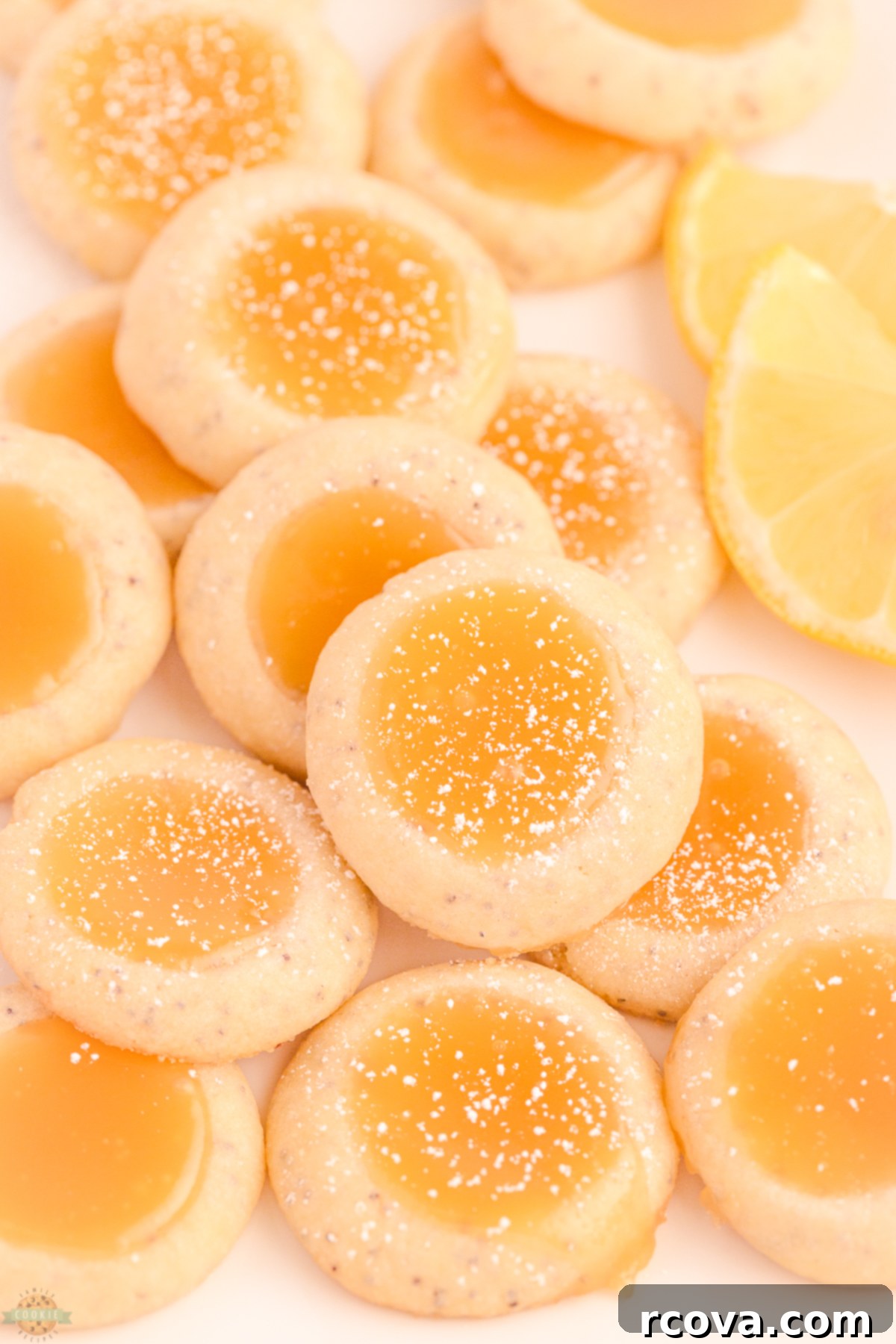 THUMBPRINT COOKIES WITH POPPY SEED 6 Close-up of Poppy Seed Thumbprint Cookies with bright yellow lemon curd filling, arranged neatly on a cooling rack.