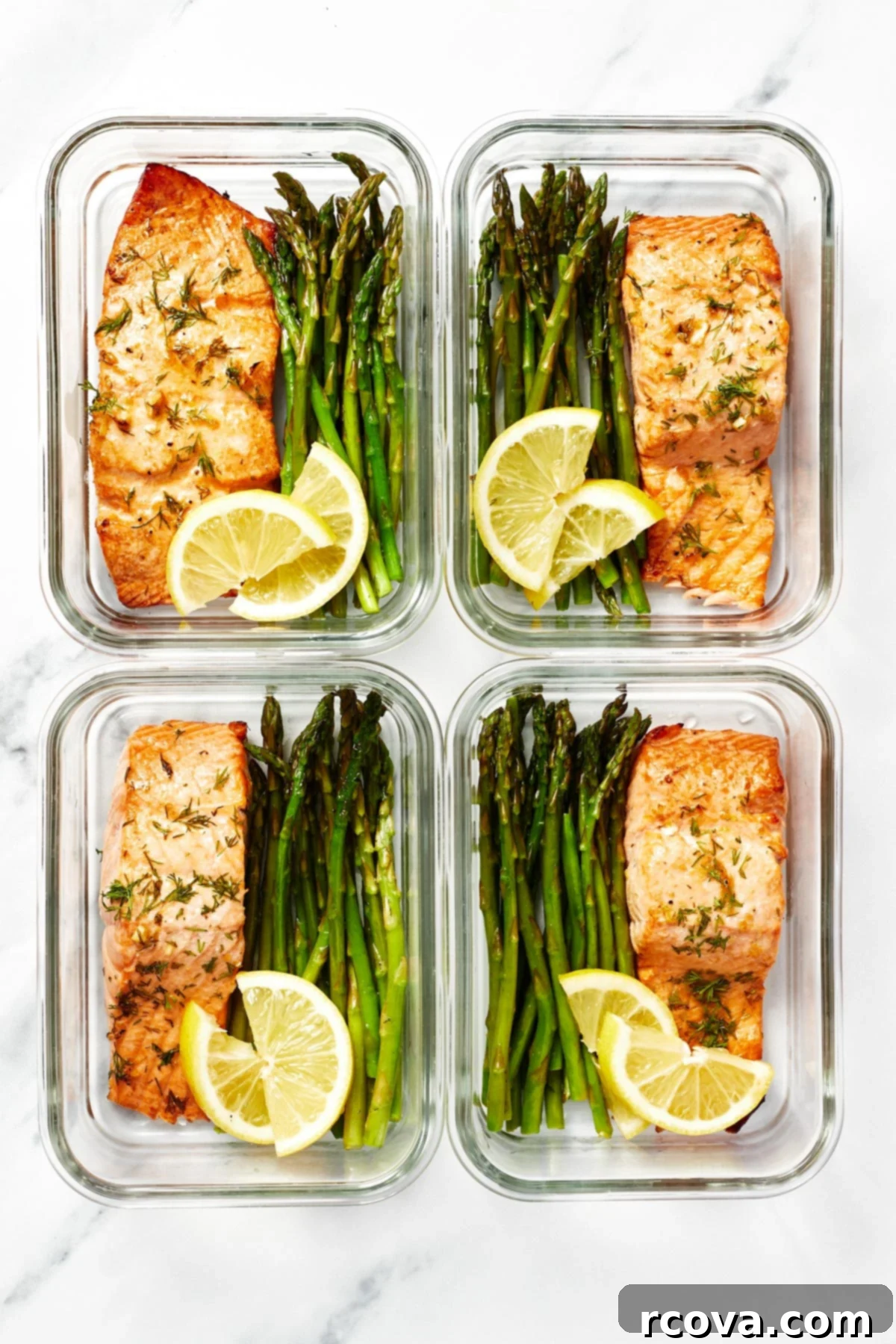 30-Minute Air Fryer Salmon 8 Four glass meal prep containers, each perfectly portioned with a delicious air-fried salmon fillet, tender asparagus spears, and two bright lemon slices, ready for healthy meals.
