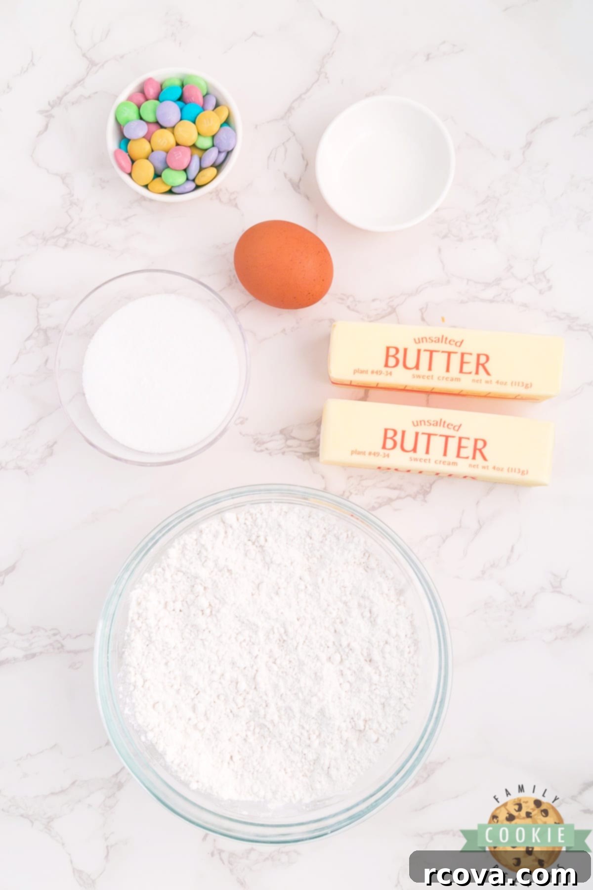Buttery Spring Spritz Delights 4 All essential ingredients for Spring Spritz Cookies, including butter, sugar, flour, egg, almond extract, and pastel M&M's.