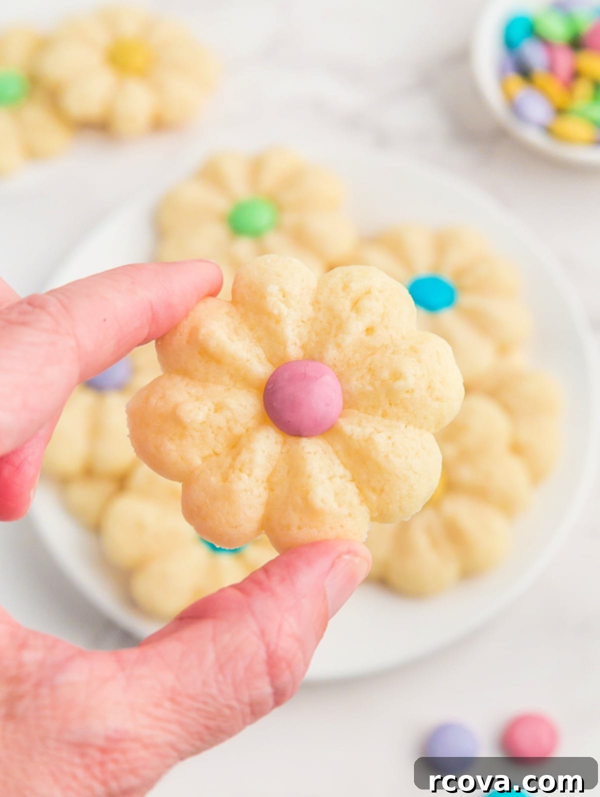 Buttery Spring Spritz Delights 6 Close-up of a single flower-shaped Spritz cookie with a colorful M&M in its center.