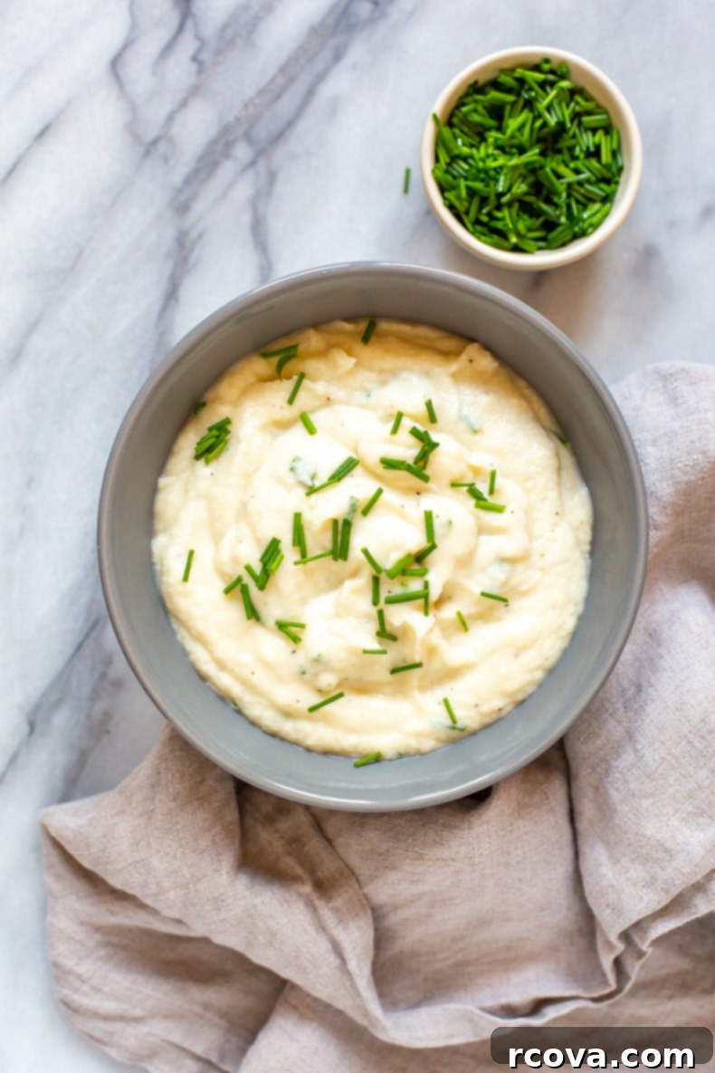 Healthy 5-Ingredient Meals for Breakfast Lunch and Dinner 13 A rustic bowl of Creamy Cauliflower Mashed Potatoes, steaming gently, topped with fresh herbs, offering a healthy and satisfying side dish.