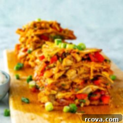 Your New Favorite Chicken Quesadilla 11 Stacks of cut chicken quesadillas on a wooden cutting board with sour cream on the side.