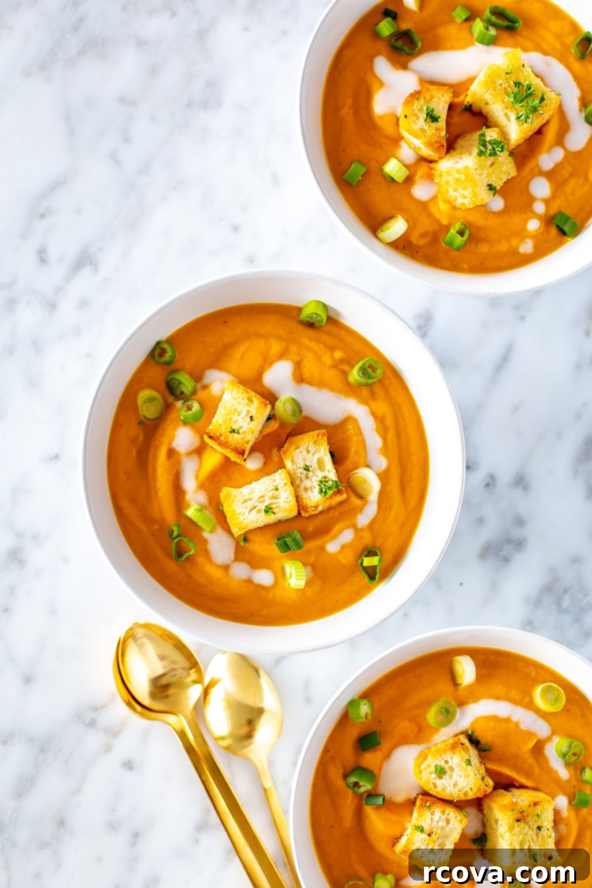 Velvety Vegan Coconut Carrot Ginger Soup 6 An overhead shot of three bowls of creamy carrot ginger soup.