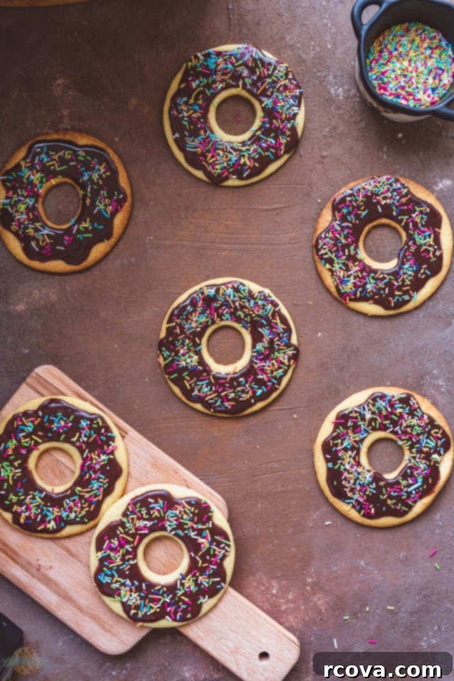 Donut Shop Chocolate Glazed Cookies 4 Dough being rolled out on a floured surface with a rolling pin and cookie cutters