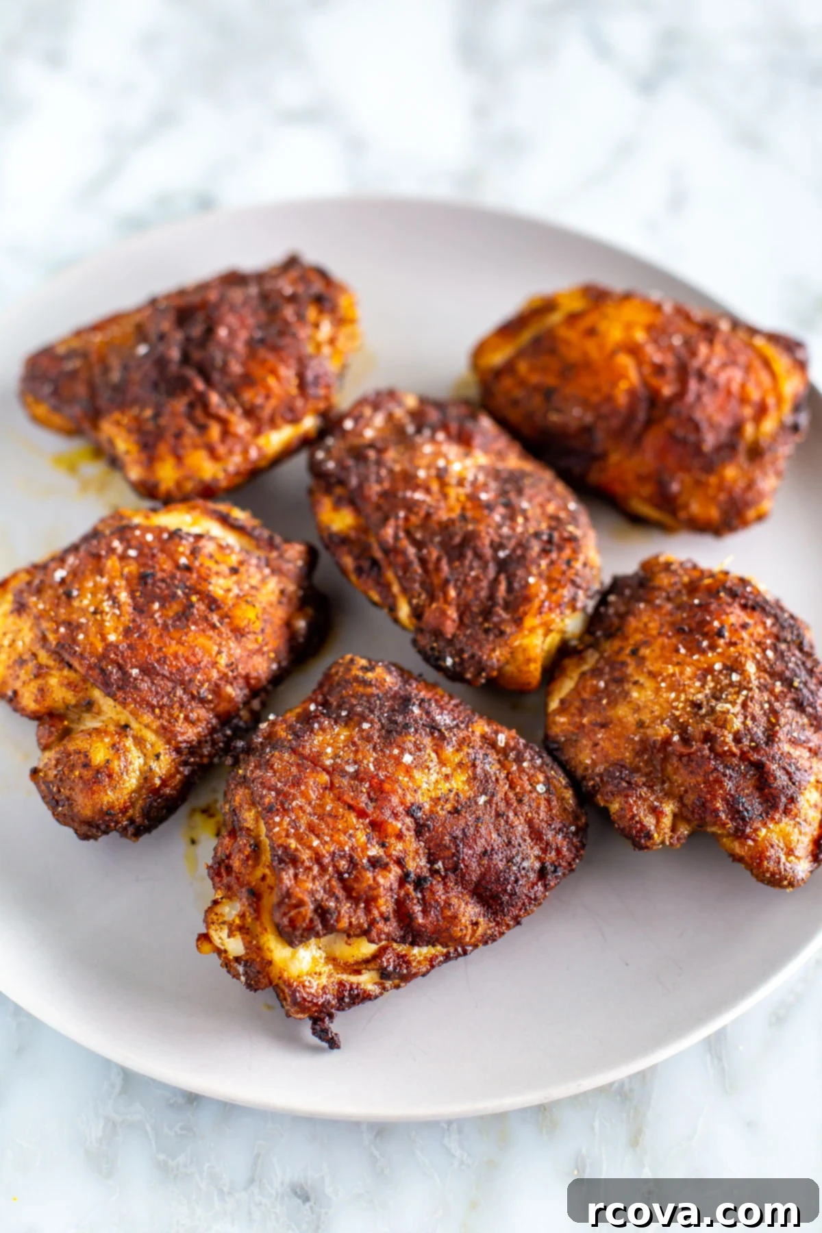 Versatile Air Fryer Chicken Thighs Bone In Or Boneless 7 Close-up shot of crispy, golden-brown air fryer chicken thighs presented beautifully on a plate, highlighting the perfectly rendered skin and succulent meat.