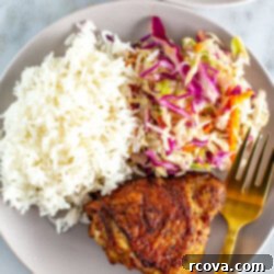 Versatile Air Fryer Chicken Thighs Bone In Or Boneless 9 Air fryer chicken thighs with coleslaw and rice on a plate