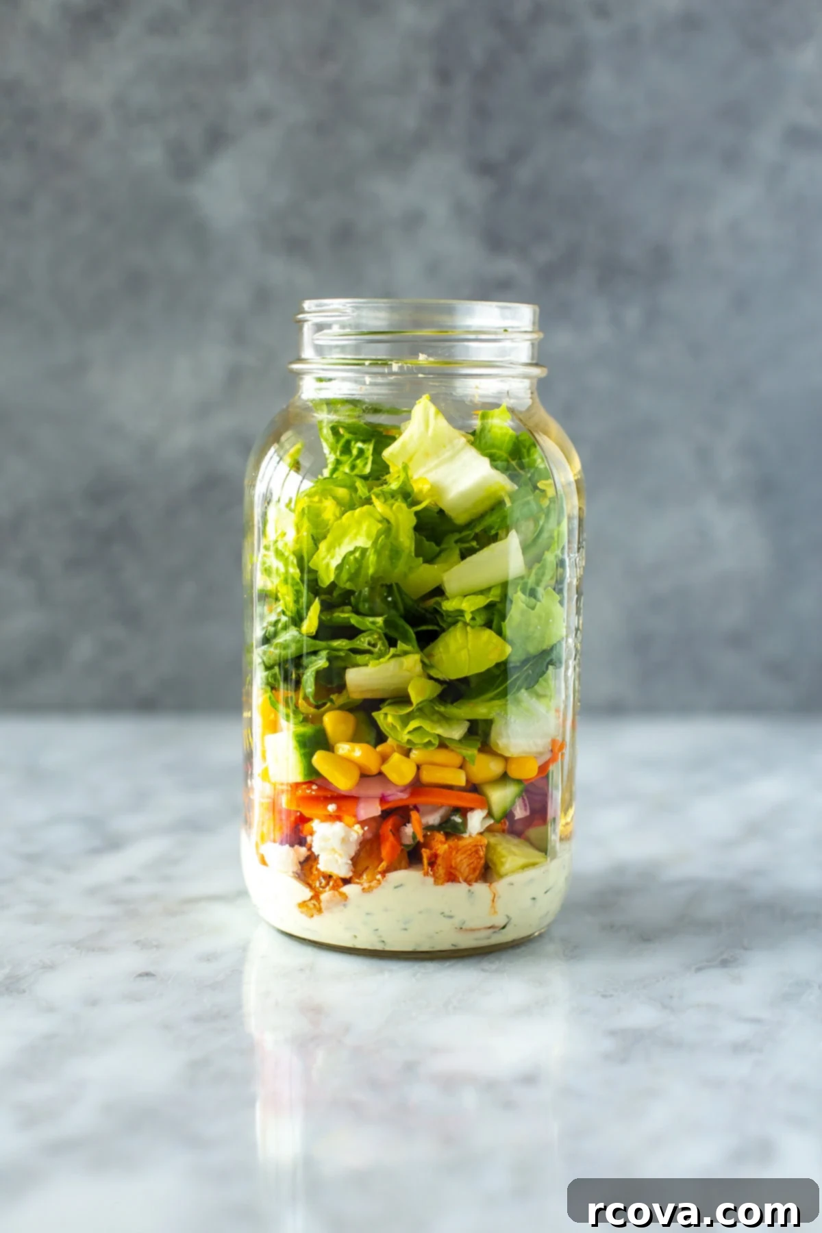 Lightened Up Buffalo Chicken Salad 9 A large mason jar filled with layers of buffalo chicken salad, perfectly prepped for a healthy lunch.