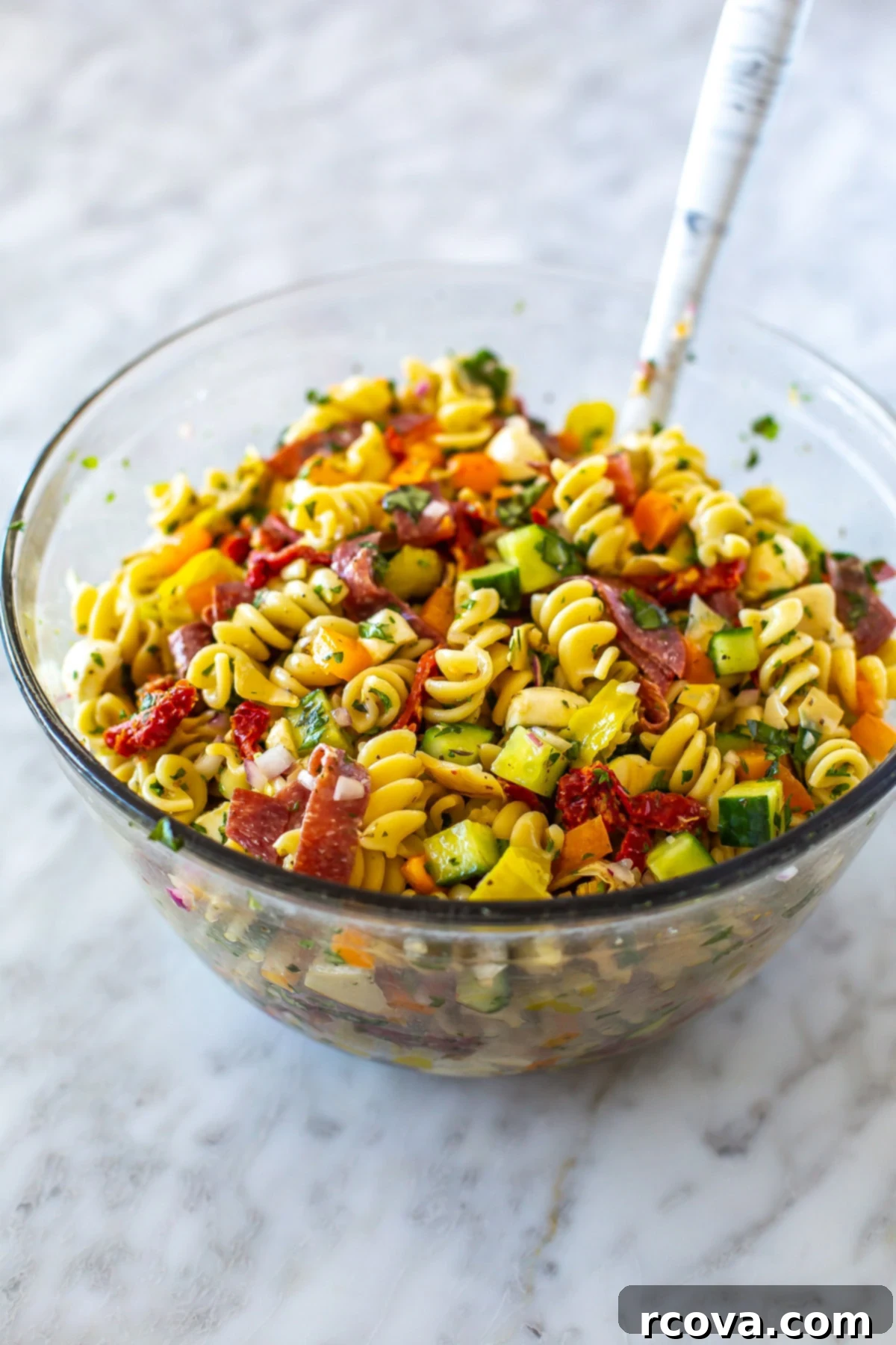 The Ultimate Italian Pasta Salad 6 A big bowl filled with Italian pasta salad with a spoon in it.