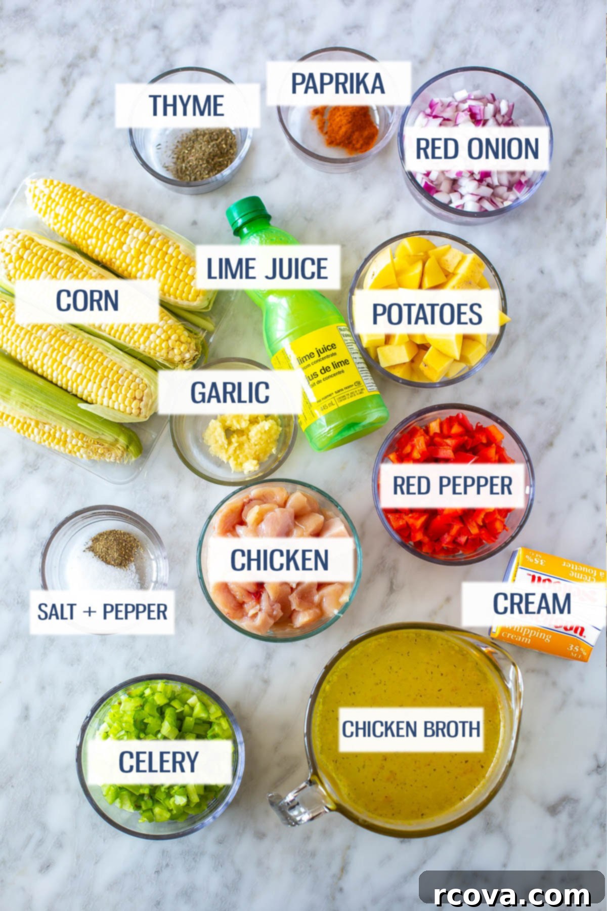 Easy Creamy Chicken Corn Chowder 4 Ingredients for chicken corn chowder: thyme, paprika, red onion, corn, lime juice, potatoes, garlic, red pepper, chicken breast, cream, celery, chicken broth, salt and pepper laid out on a wooden board.